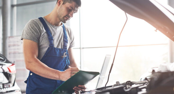 Muscular Car Service Worker Repairing Vehicle