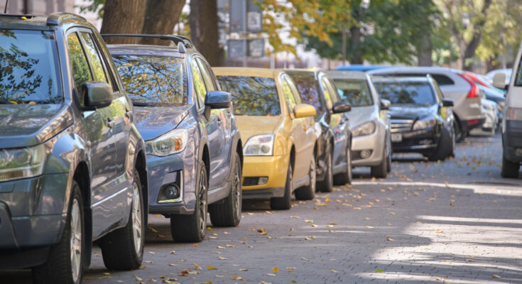 City Traffic With Many Cars Parked Line Street Side