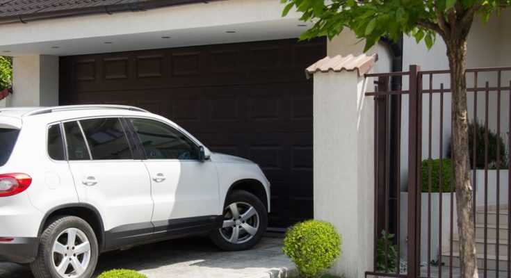 19523719 White Car In Front Of The House Waiting To Enter In The Garage